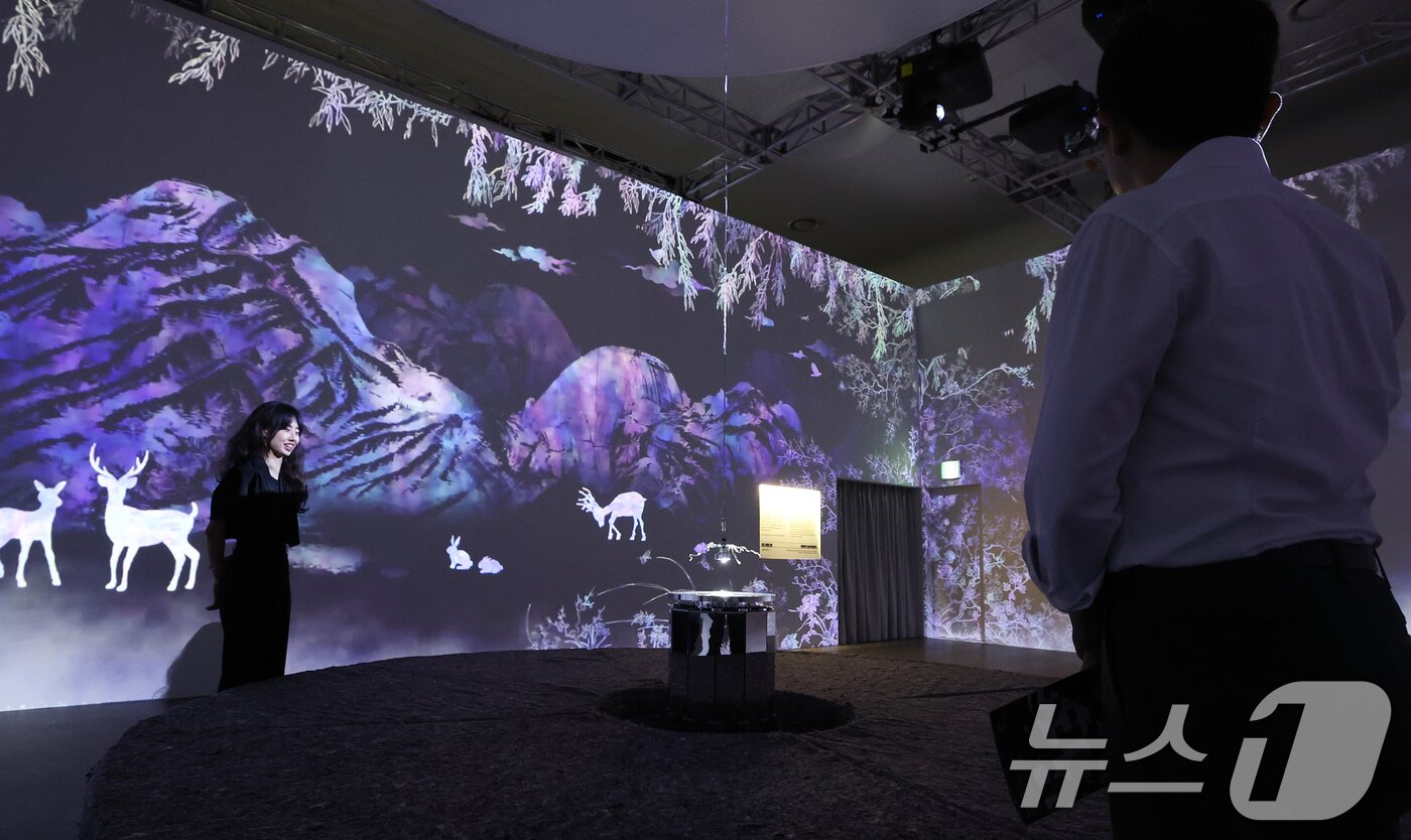 본문 이미지 - 19일 서울 동대문구 동대문디자인플라자(DDP)에서 열린 국가유산 활용 디지털 콘텐츠 전시 '헤리티지: 더 퓨처 판타지' 언론 공개회에서 방문객들이 한국 전통 산수를 자개의 빛깔로 표현한 '산수, 끝없는 윤슬'을 관람하고 있다.   2025.8.19/뉴스1 ⓒ News1 오대일 기자