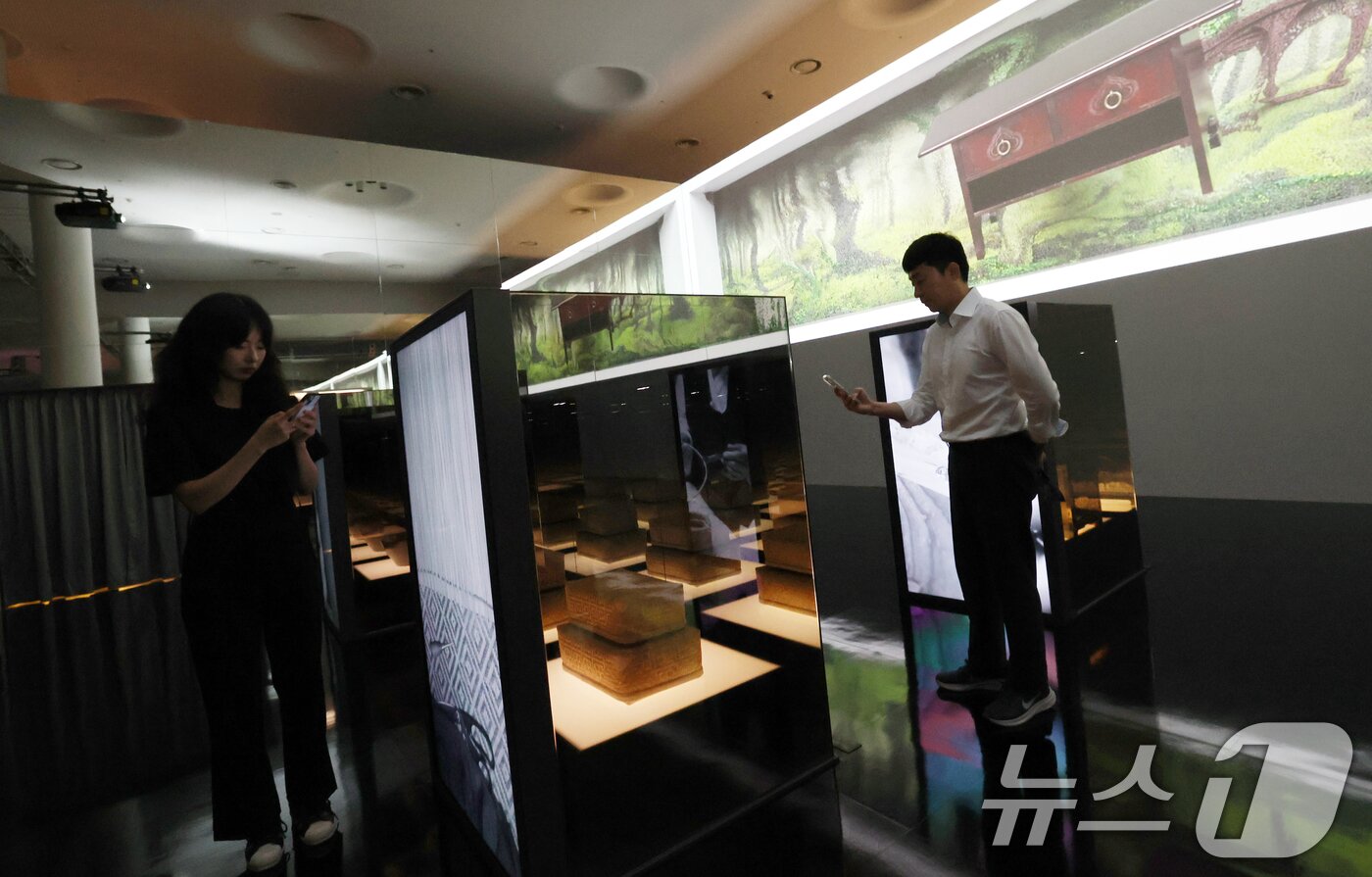 본문 이미지 - 19일 서울 동대문구 동대문디자인플라자(DDP)에서 열린 국가유산 활용 디지털 콘텐츠 전시 '헤리티지: 더 퓨처 판타지' 언론 공개회에서 방문객들이 국가무형유산 장인들의 공예기술을 소개하는 '자연으로부터'를 관람하고 있다.  2025.8.19/뉴스1 ⓒ News1 오대일 기자