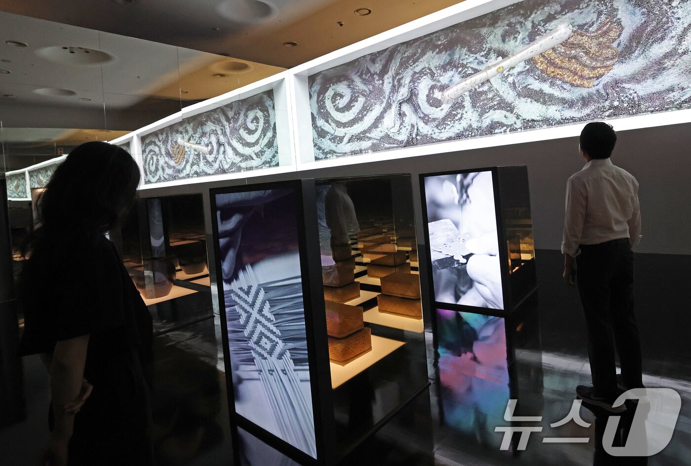 본문 이미지 - 19일 서울 동대문구 동대문디자인플라자(DDP)에서 열린 국가유산 활용 디지털 콘텐츠 전시 '헤리티지: 더 퓨처 판타지' 언론 공개회에서 방문객들이 국가무형유산 장인들의 공예기술을 소개하는 '자연으로부터'를 관람하고 있다.  2025.8.19/뉴스1 ⓒ News1 오대일 기자