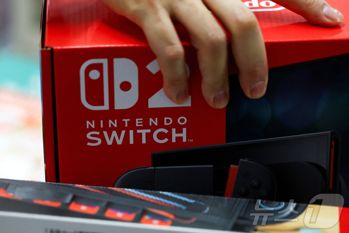 본문 이미지 - &#39;닌텐도 스위치 2&#39;가 출시된 2025년 6월 5일, 일본 도쿄의 전자 제품 매장에서 한 이용자가 닌텐도 스위치 2를 들고 있다.2025.6.5 ⓒ 로이터=뉴스1 ⓒ News1 김민재 기자
