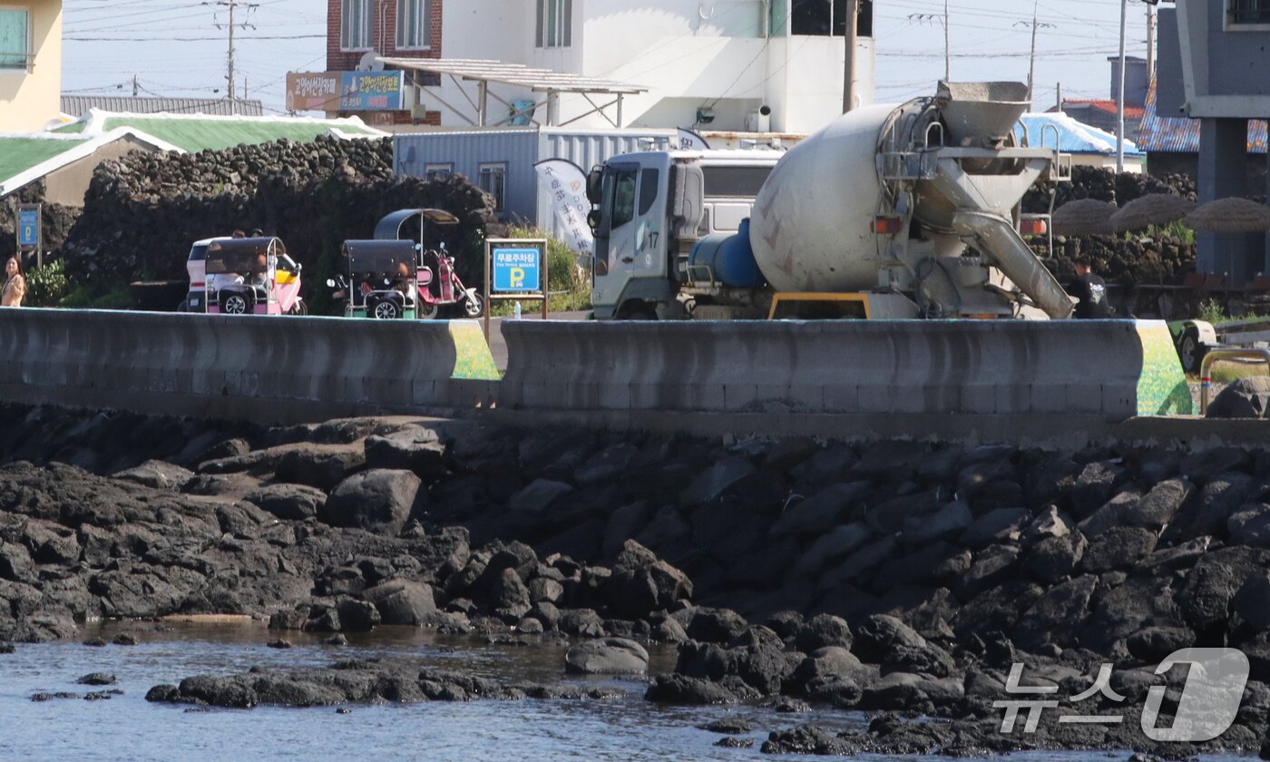 본문 이미지 - 지난 1일 오전 제주에서 운행 중인 이륜차 뒤로 레미콘차량이 지나가고 있다.