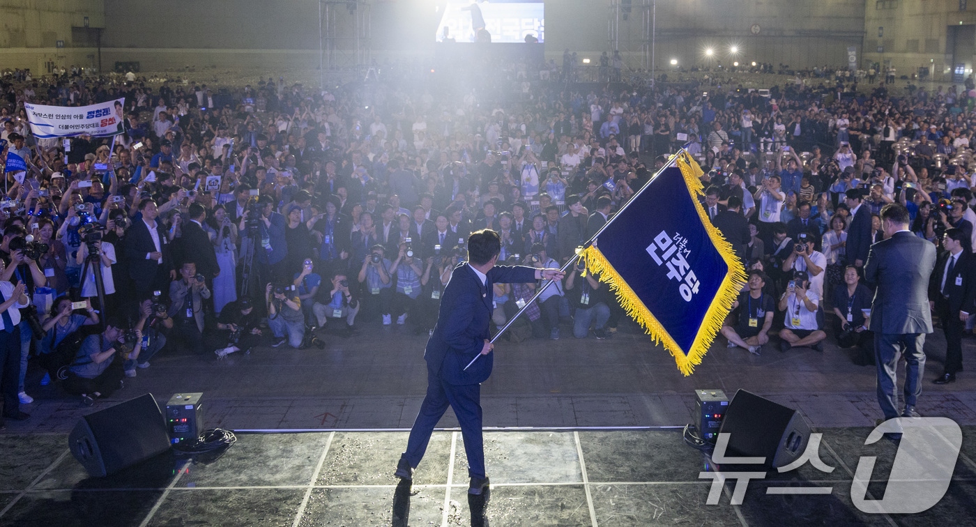 (고양=뉴스1) 유승관 기자 = 정청래 더불어민주당 신임 당대표가 2일 경기 고양시 킨텍스에서 열린 제2차 임시전국당원대회에서 당기를 흔들고 있다. (공동취재) 2025.8.2/뉴 …