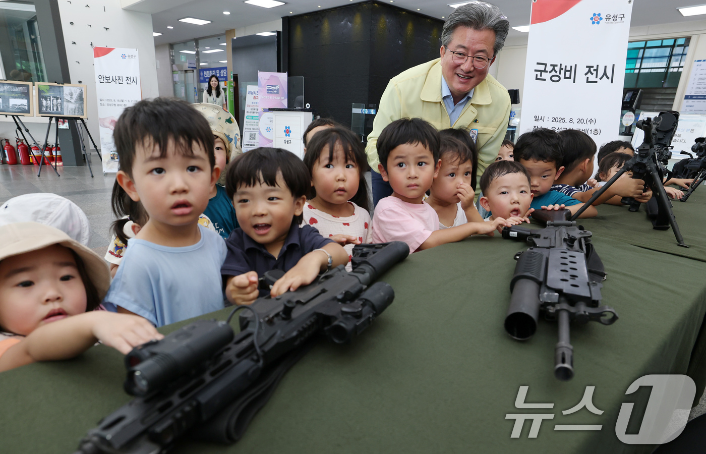 (대전=뉴스1) 김기태 기자 = 정용래 대전 유성구청장이 을지연습 기간인 20일 유성구청 로비에서 어린이집 원생들에게 안보사진과 군무기 전시에 대해 설명하고 있다.   2025.8 …