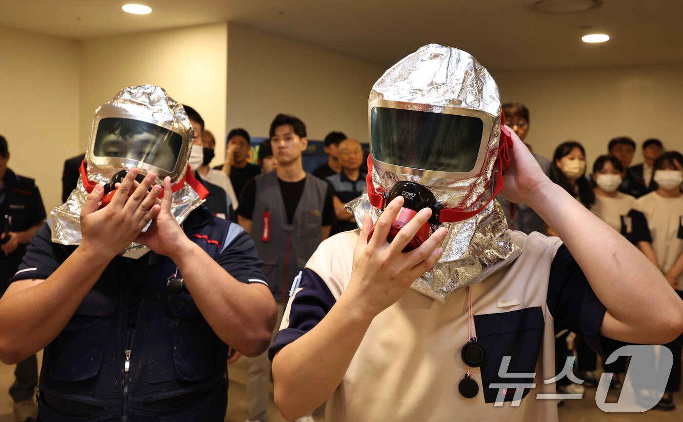본문 이미지 - 20일 오후 서울 송파구 롯데월드몰에서 열린 다중이용시설 민방공 대피훈련에서 직원들이 화생방 상황에 대비해 방독면을 착용하고 있다. 2025.8.20/뉴스1 ⓒ News1 구윤성 기자
