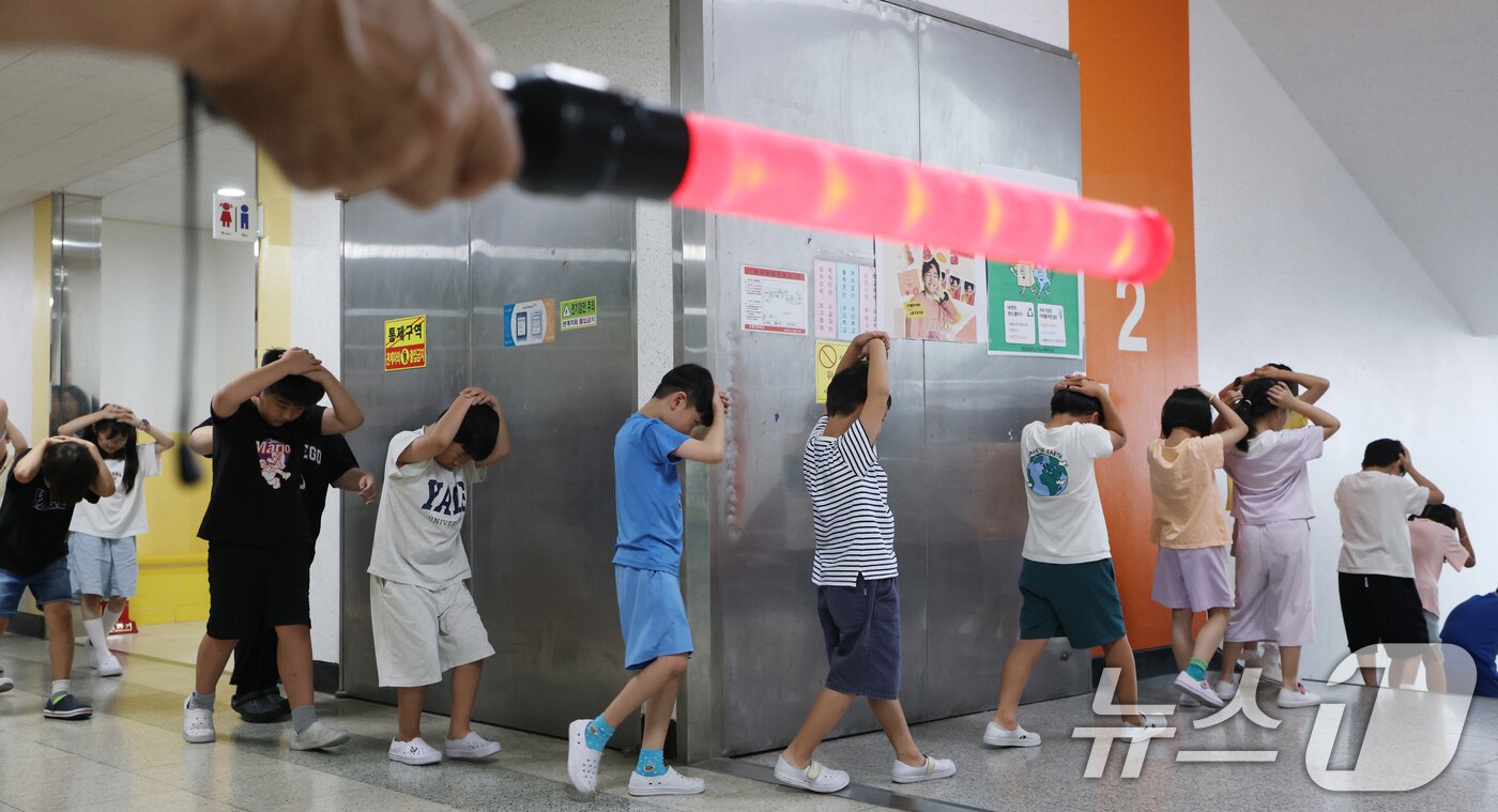 본문 이미지 - 전국 단위 민방위 대피훈련이 실시된 20일 오후 경기 수원시 영통구 효동초등학교에서 학생들이 적 공습 상황에 대비한 민방위 대피훈련을 하고 있다. 2025.8.20/뉴스1 ⓒ News1 김영운 기자