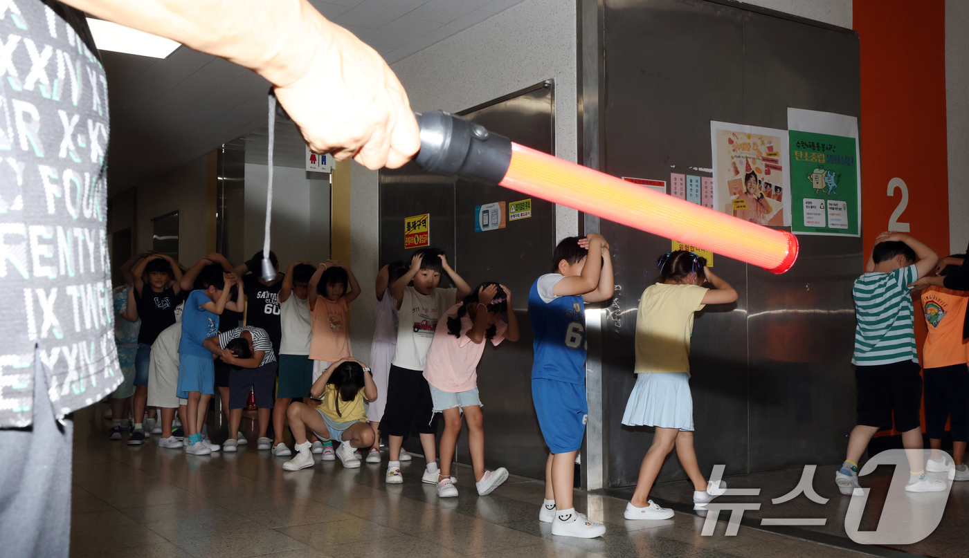 (수원=뉴스1) 김영운 기자 = 전국 단위 민방위 대피훈련이 실시된 20일 오후 경기 수원시 영통구 효동초등학교에서 학생들이 적 공습 상황에 대비한 민방위 대피훈련을 하고 있다. …