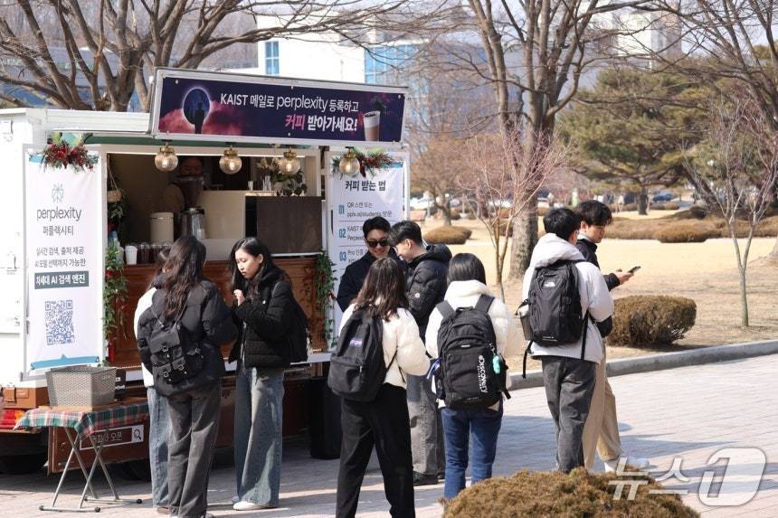 본문 이미지 - 대학생 마케터들이 카이스트에서 커피 증정행사를 진행하고 있다.&#40;퍼플렉시티 제공&#41;