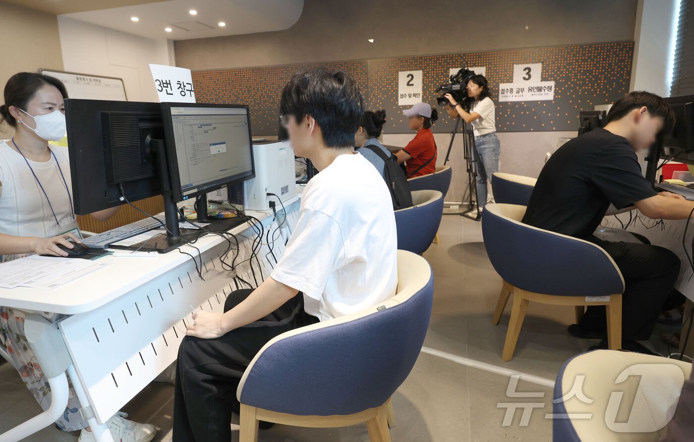 본문 이미지 - 2026학년도 수능 응시원서 접수가 시작된 21일 수험생과 대리인이 서울 양천구 강서양천교육지원청 접수센터에서 응시원서를 접수하고 있다. 2025.8.21/뉴스1 ⓒ News1 사진공동취재단