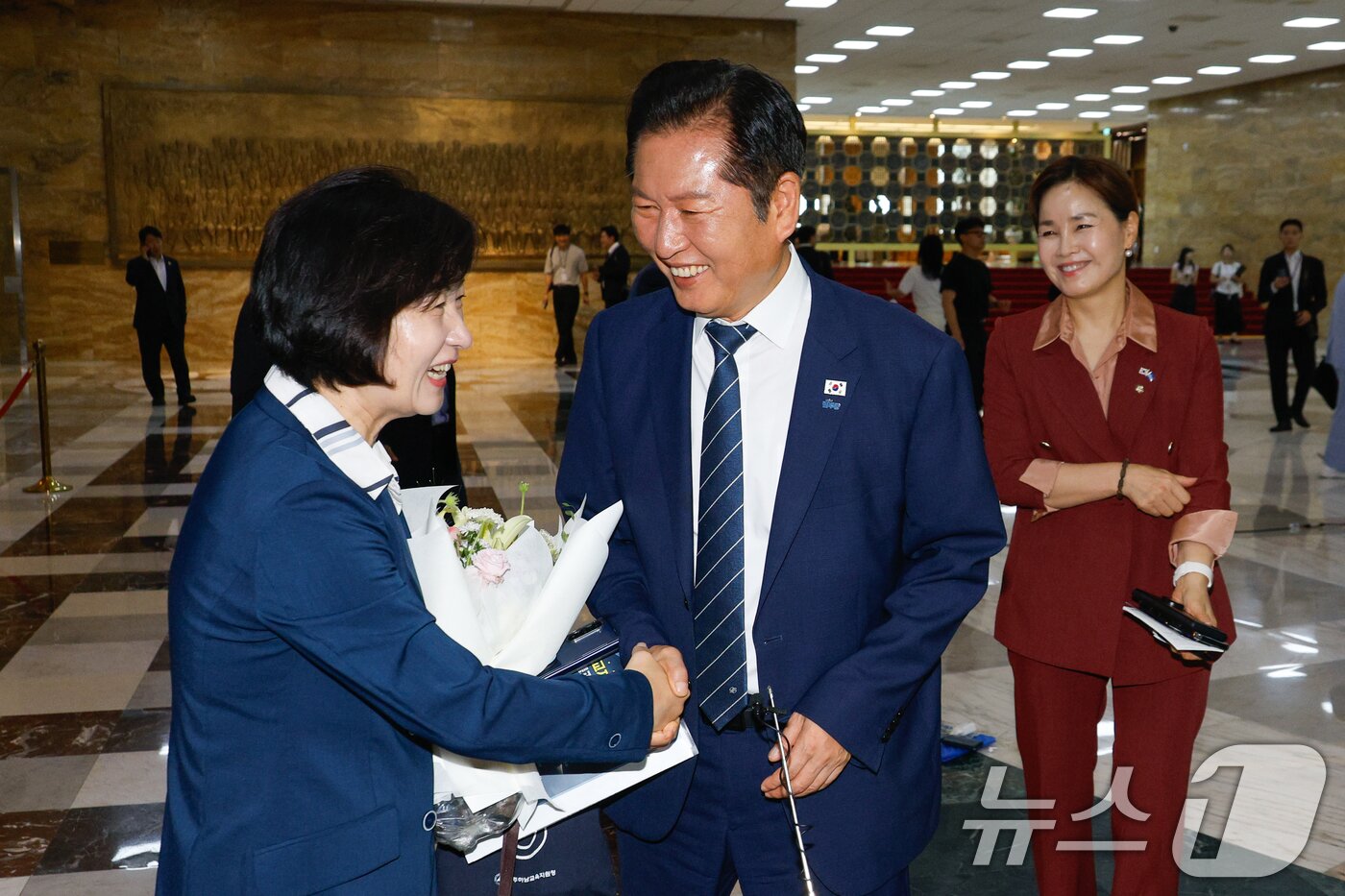 본문 이미지 - 추미애 신임 법제사법위원회 위원장이 21일 서울 여의도 국회 본회의장 앞에서 법사위 직원들로부터 꽃다발을 받은 뒤 정청래 더불어민주당 대표의 축하를 받고 있다. 2025.8.21/뉴스1 ⓒ News1 안은나 기자