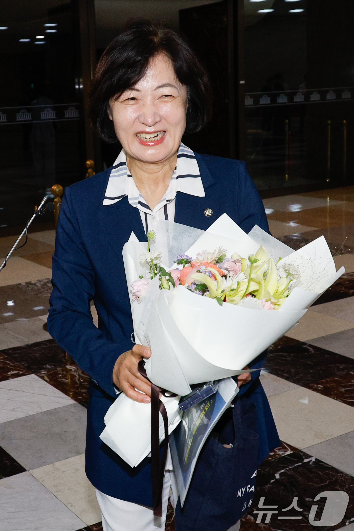 (서울=뉴스1) 안은나 기자 = 추미애 신임 법제사법위원회 위원장이 21일 서울 여의도 국회 본회의장 앞에서 법사위 직원들로부터 꽃다발을 받고 있다. 2025.8.21/뉴스1