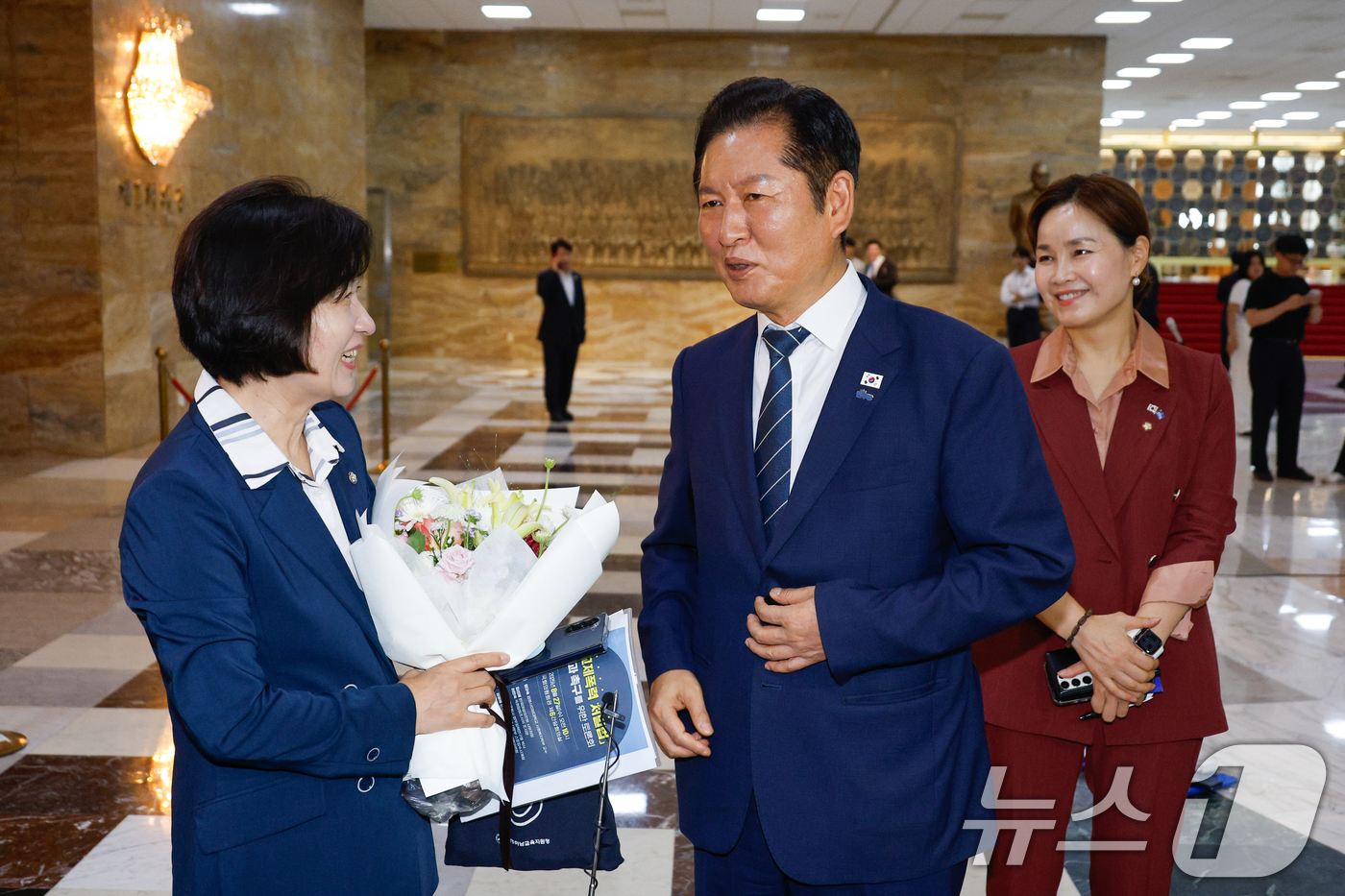 (서울=뉴스1) 안은나 기자 = 추미애 신임 법제사법위원회 위원장이 21일 서울 여의도 국회 본회의장 앞에서 법사위 직원들로부터 꽃다발을 받은 뒤 정청래 더불어민주당 대표의 축하를 …