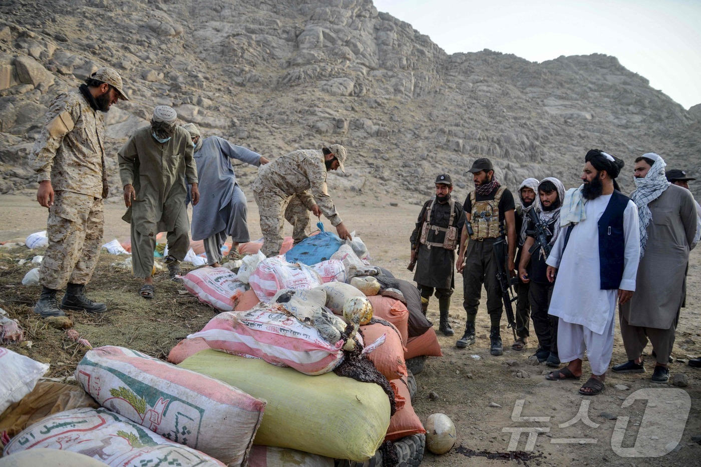 (스핀 볼닥 AFP=뉴스1) 권영미 기자 = 20일(현지시간) 탈레반 대원들이 칸다하르의 스핀 볼닥 지역 한 들판에서 압수된 마약을 소각하기 위해 준비 중인 보안 요원들을 점검하고 …