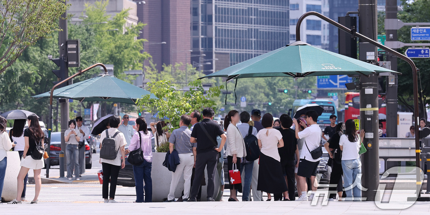 (서울=뉴스1) 박지혜 기자 = 절기상 ‘처서’가 이틀 앞으로 다가왔지만 여전히 찜통 더위가 이어진 21일 오후 서울 광화문네거리에서 시민들이 횡단보도 앞 그늘막 아래 모여 신호를 …