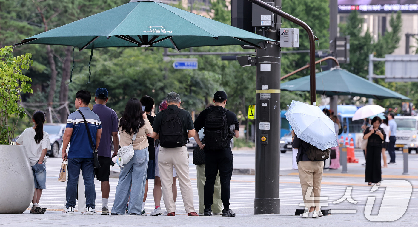 (서울=뉴스1) 박지혜 기자 = 절기상 ‘처서’가 이틀 앞으로 다가왔지만 여전히 찜통 더위가 이어진 21일 오후 서울 광화문네거리에서 시민들이 횡단보도 앞 그늘막 아래 모여 신호를 …