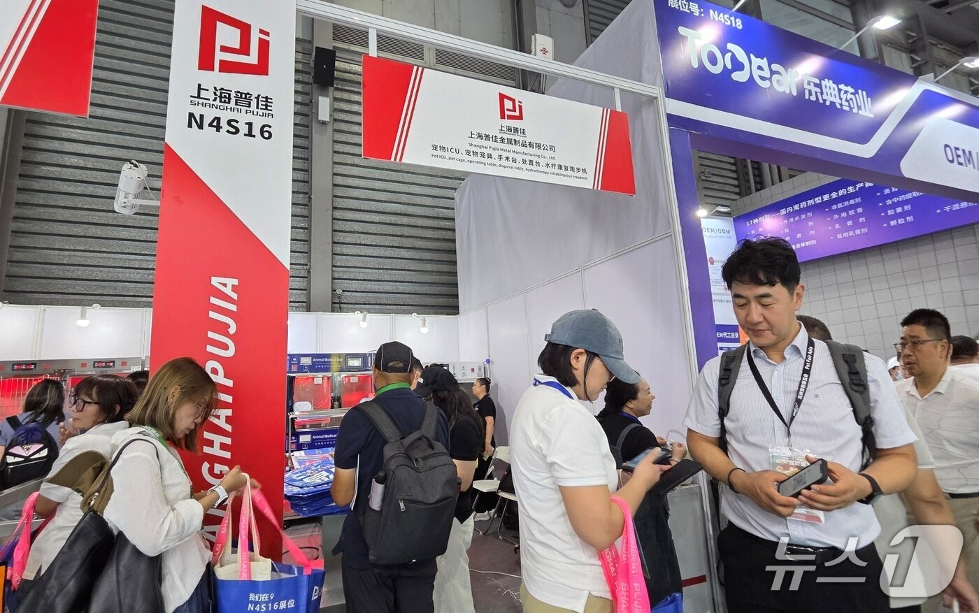 본문 이미지 - 최이돈 한국동물병원협회 회장이 20일 중국 상하이에서 열린 펫페어아시아에서 &#39;파사바 2025&#39; 참가 기업 관계자와 대화를 하고 있다. ⓒ 뉴스1 최서윤 기자
