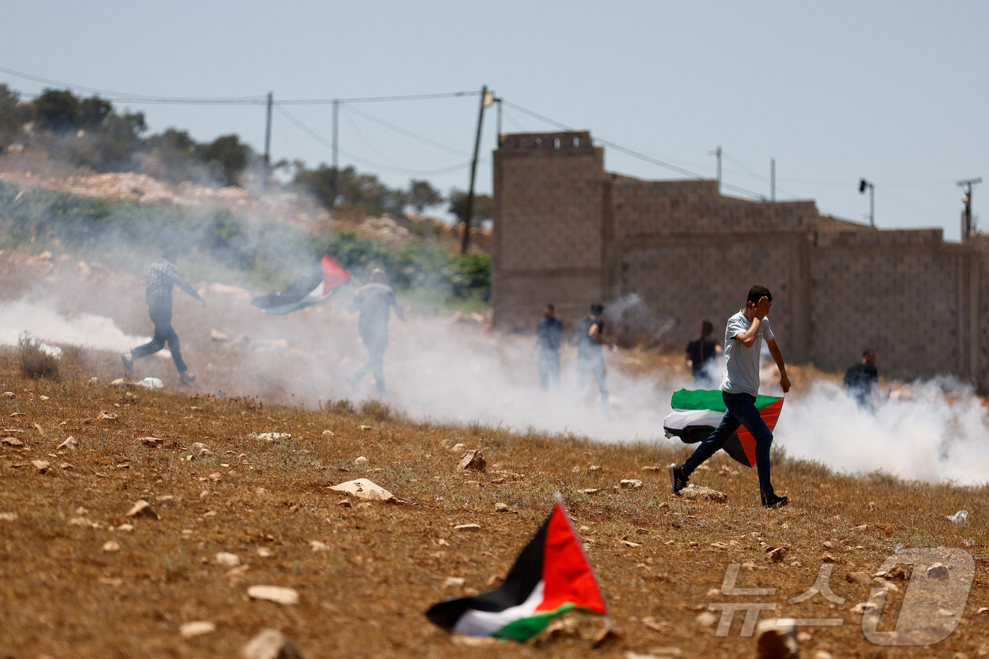 (라바 로이터=뉴스1) 김경민 기자 = 이스라엘이 점령한 서안지구 제닌 근처 라바에서 시위를 벌이고 있는 팔레스타인인들과 경계를 서고 있는 이스라엘군. 2025.7.18ⓒ 로이터= …