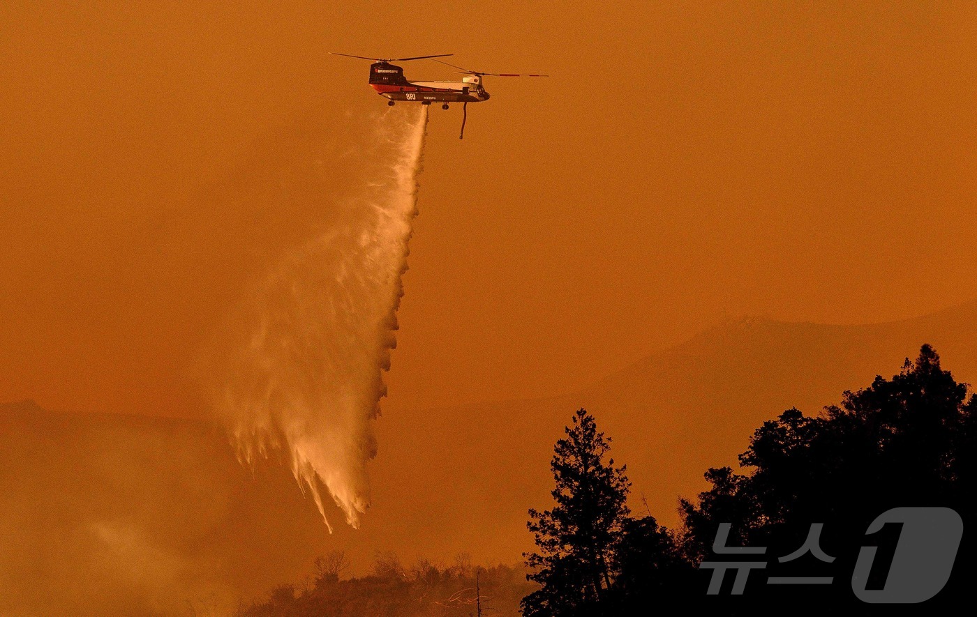 (칼리스토가 AFP=뉴스1) 김지완 기자 = 21일(현지시간) 미국 캘리포니아주 칼리스토가에서 산불이 발생해 소방 헬기가 물을 뿌리고 있다. 이 산불로 인해 불과 몇 시간 만에 4 …