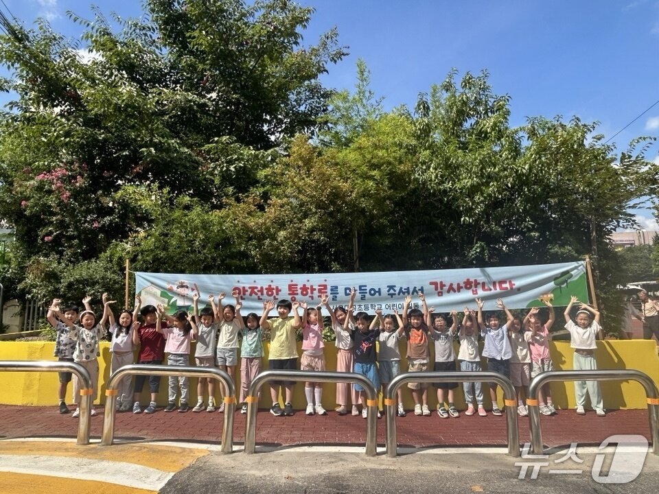 본문 이미지 - 안전 통학로 공사 후 대곡초 학생들이 새단장한 등굣길 위에서 만세 포즈를 취하고 있다. 2025.08.22/(수서서 제공)