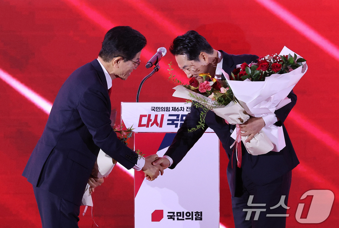 (청주=뉴스1) 신웅수 기자 = 김문수(왼쪽)·장동혁 국민의힘 당대표 후보가 22일 오후 충북 청주시 오스코에서 열린 제6차 전당대회에서 결선 진출에 성공한 뒤 악수를 나누고 있다 …