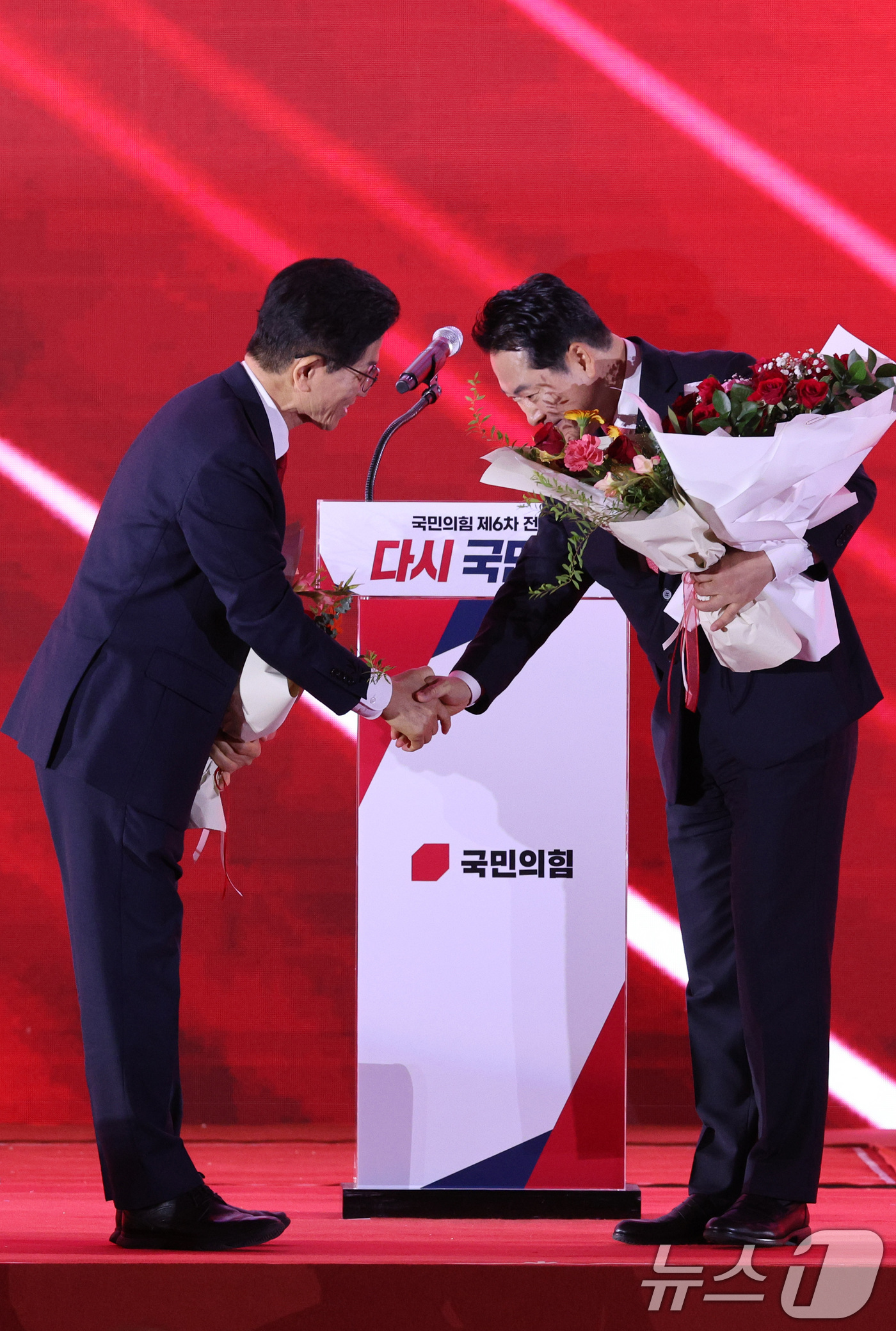 (청주=뉴스1) 신웅수 기자 = 김문수(왼쪽)·장동혁 국민의힘 당대표 후보가 22일 오후 충북 청주시 오스코에서 열린 제6차 전당대회에서 결선 진출에 성공한 뒤 악수를 나누고 있다 …