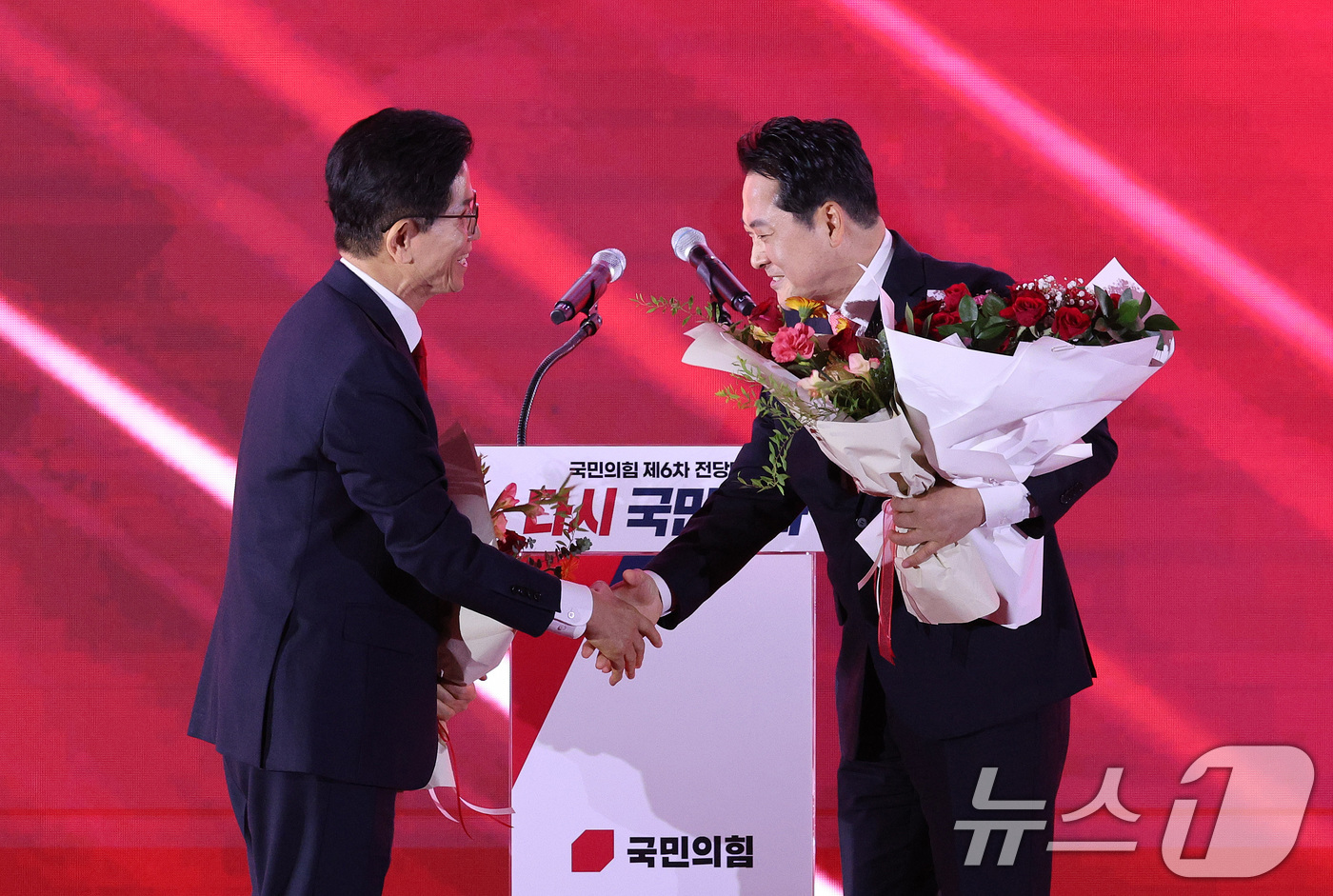 (청주=뉴스1) 신웅수 기자 = 김문수(왼쪽)·장동혁 국민의힘 당대표 후보가 22일 오후 충북 청주시 오스코에서 열린 제6차 전당대회에서 결선 진출에 성공한 뒤 악수를 나누고 있다 …