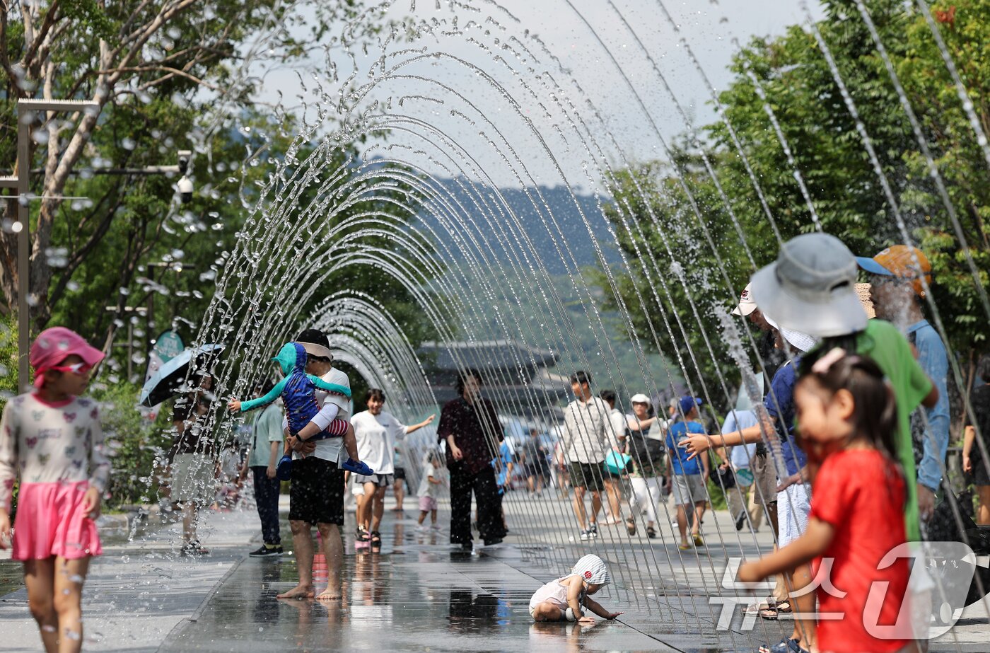 본문 이미지 - 제주 한라산을 제외한 전역에 폭염특보가 내려지는 등 늦더위가 기승을 부린 24일 오후 서울 종로구 광화문광장 분수 터널에서 시민들이 더위를 식히고 있다. 2025.8.24/뉴스1 ⓒ News1 오대일 기자