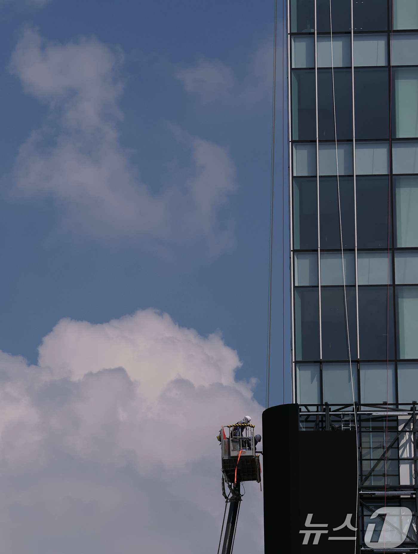 (서울=뉴스1) 오대일 기자 = 한국판 타임스스퀘어를 표방하는 광화문스퀘어 조성 사업이 본격화한 가운데 24일 오후 서울 종로구 KT 광화문 웨스트 사옥 외벽에서 노동자들이 새하얀 …