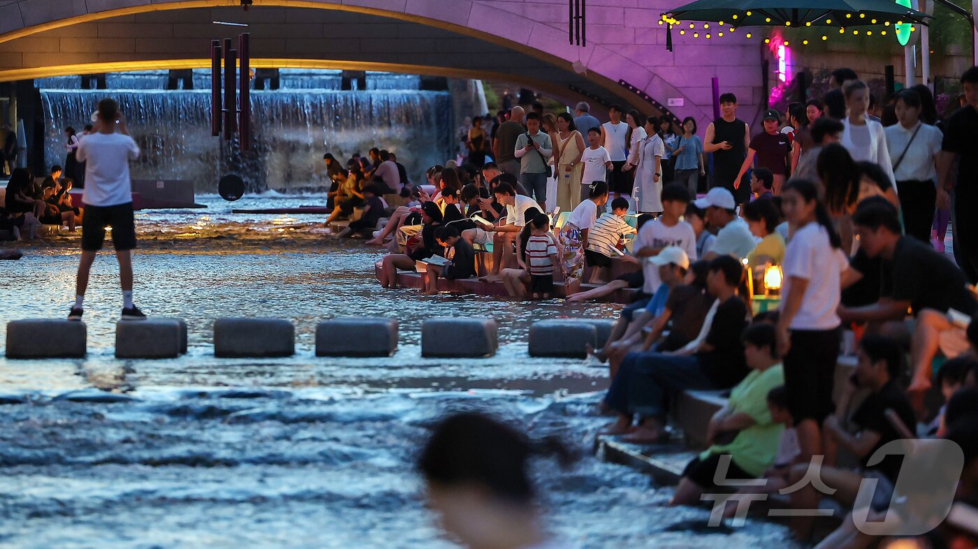 본문 이미지 - 열대야가 이어지고 있는 24일 저녁 서울 중구 청계천을 찾은 시민들이 더위를 식히고 있다. 2025.8.24/뉴스1 ⓒ News1 김진환 기자