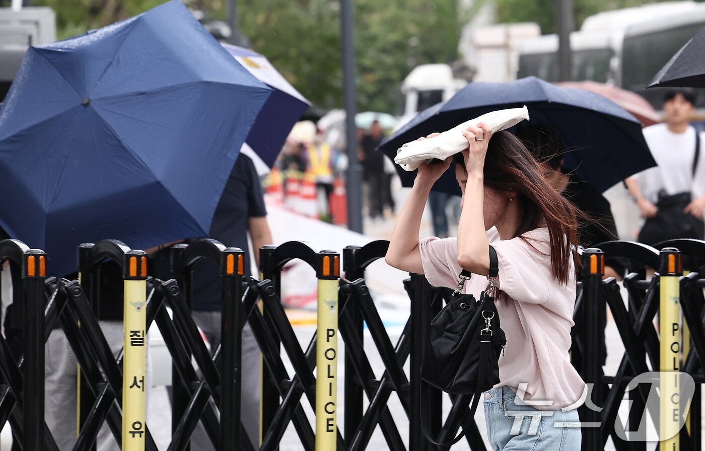 본문 이미지 - 비가 내린 25일 오전 서울 종로구 광화문 일대에서 우산을 준비하지 못한 시민들이 가방으로 비를 막은 채 출근길 발걸음을 서두르고 있다. 2025.8.25/뉴스1 ⓒ News1 김성진 기자