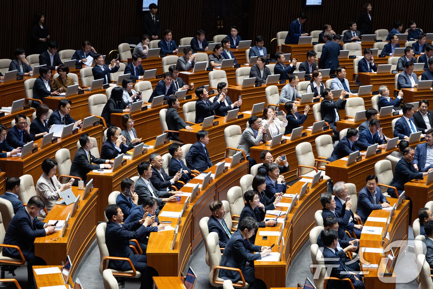 본문 이미지 - 25일 서울 여의도 국회에서 열린 제428회 국회&#40;임시회&#41; 제2차 본회의에서 상법 일부개정법률안이 통과되자 여당 의원들이 표결 결과를 휴대전화로 촬영하고 있다. 2025.8.25/뉴스1 ⓒ News1 유승관 기자