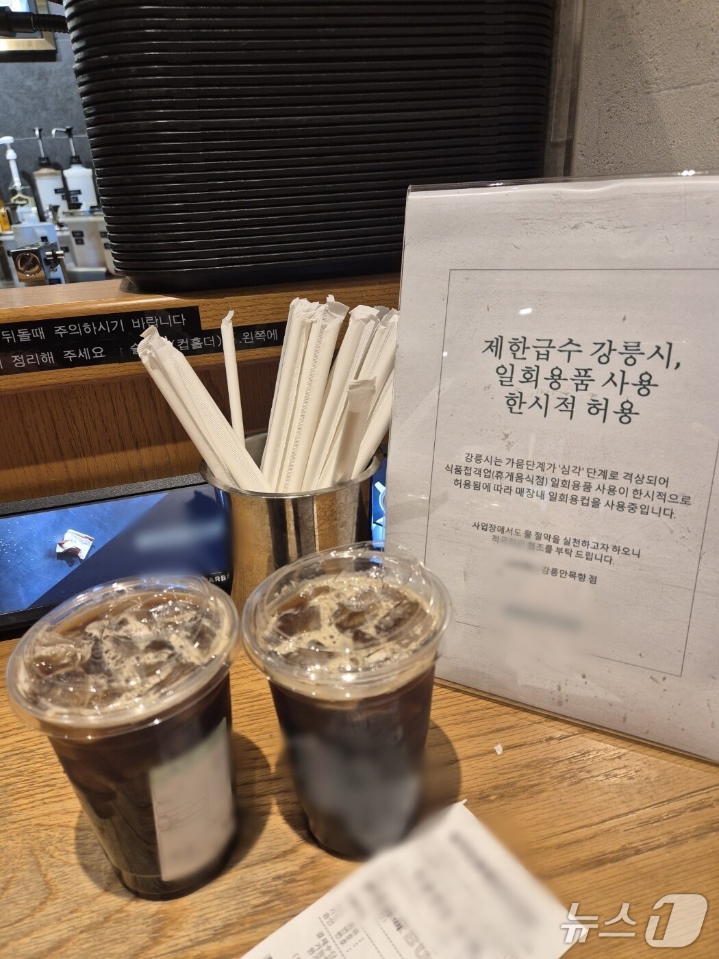 본문 이미지 - 강릉커피거리가 있는 안목해변의 한 커피전문점 매대 앞에 가뭄으로 인해 1회용품을 사용한다는 안내문이 내걸려 있다. 2025.8.26/뉴스1 윤왕근 기자