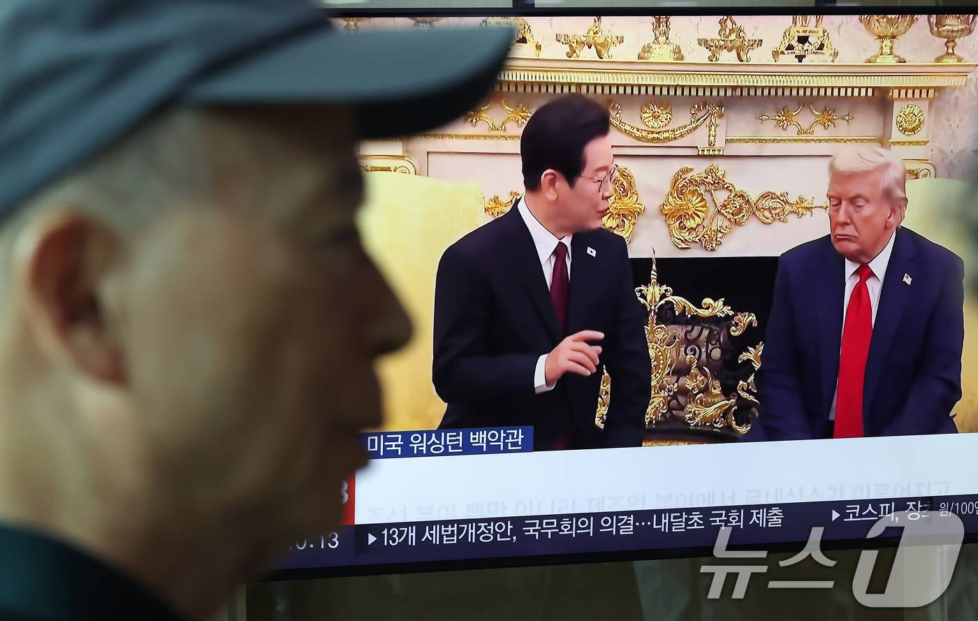 (서울=뉴스1) 박정호 기자 = 26일 오전 서울 용산구 한강대로 서울역 대합실에서 시민들이 이재명 대통령과 도널드 트럼프 미국 대통령 간 한미 정상회담 관련 뉴스를 지켜보고 있다 …