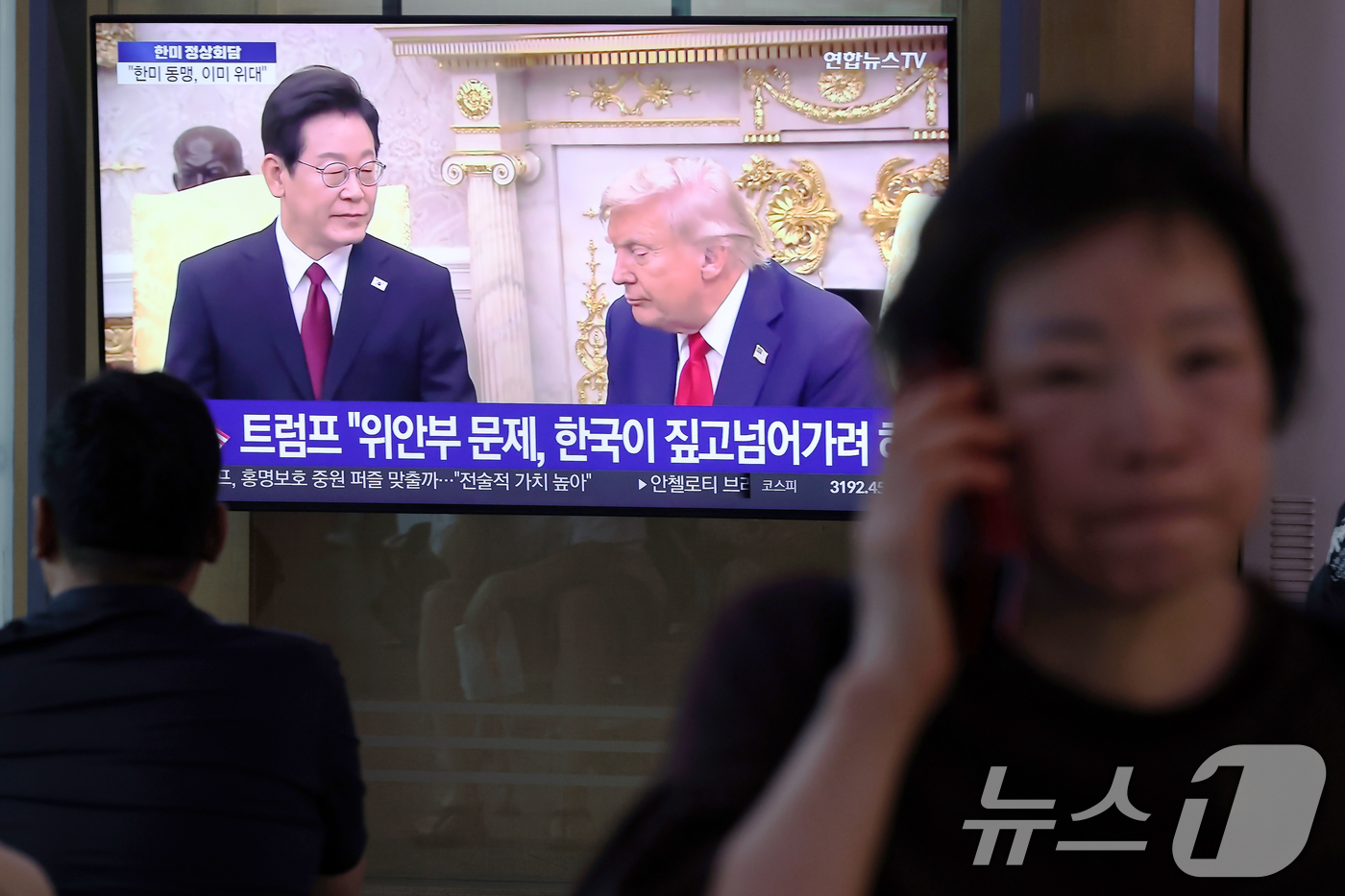 (서울=뉴스1) 박정호 기자 = 26일 오전 서울 용산구 한강대로 서울역 대합실에서 시민들이 이재명 대통령과 도널드 트럼프 미국 대통령 간 한미 정상회담 관련 뉴스를 지켜보고 있다 …