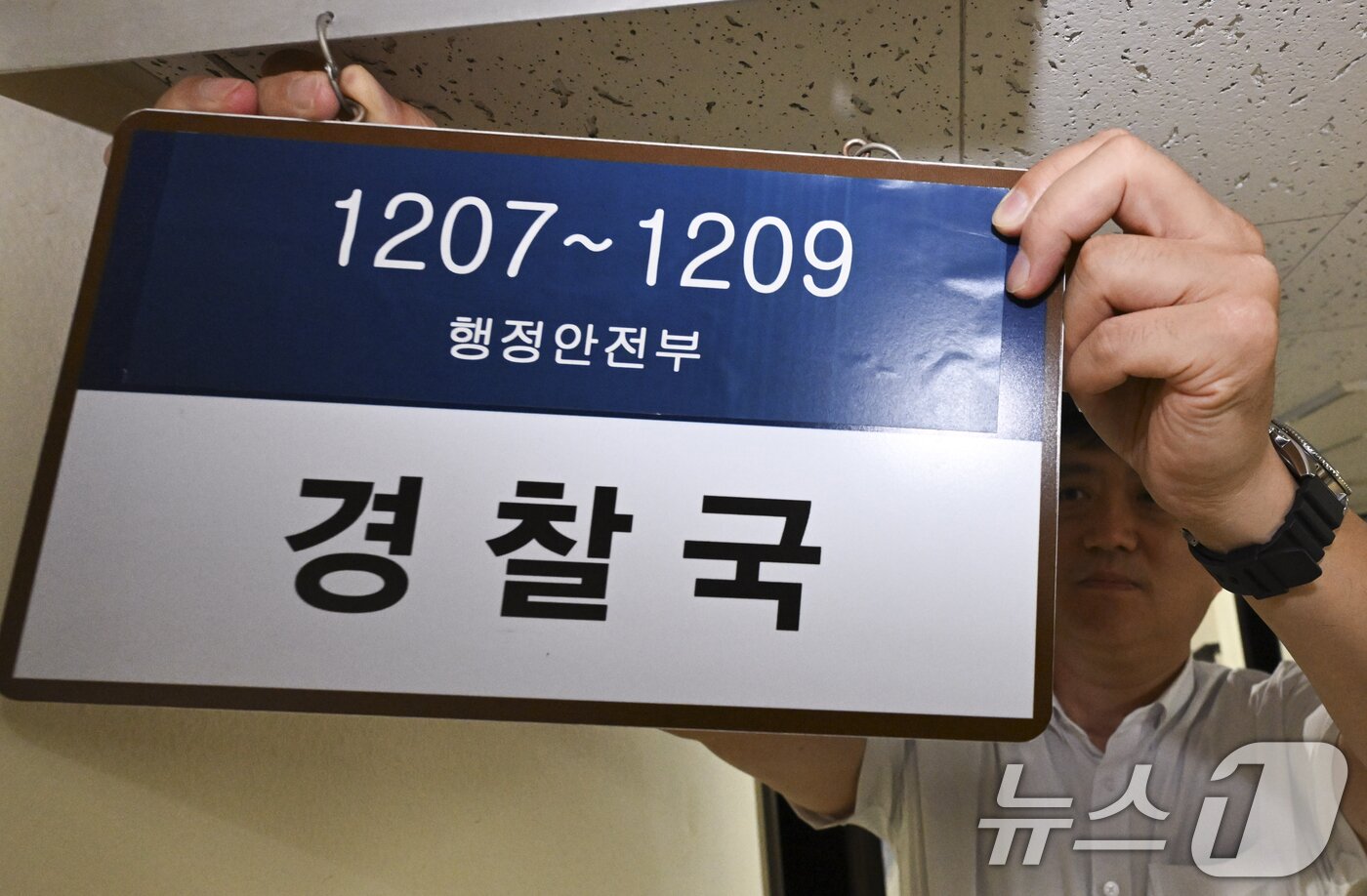 본문 이미지 - 경찰국 폐지 관련 직제 개정령안 시행일인 26일 서울 종로구 정부서울청사 행정안전부 내 경찰국 사무실 앞에서 관계자가 경찰국 간판을 철거하고 있다.  (공동취재) 2025.8.26/뉴스1 ⓒ News1 임세영 기자