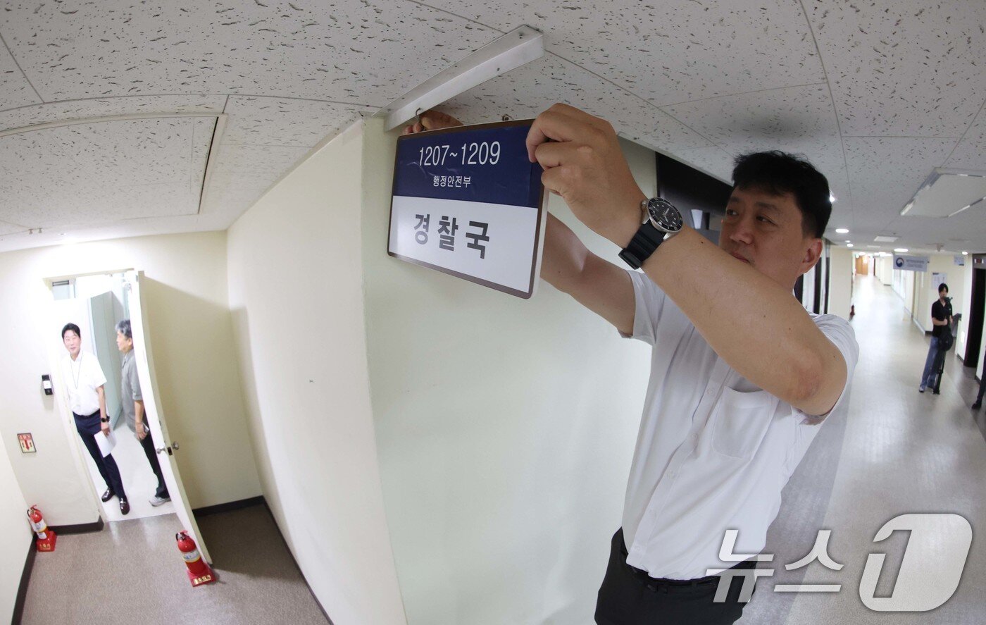 본문 이미지 - 경찰국 폐지 관련 직제 개정령안 시행일인 26일 서울 종로구 정부서울청사 행정안전부 내 경찰국 사무실 앞에서 관계자가 경찰국 간판을 철거하고 있다.  (공동취재) 2025.8.26/뉴스1 ⓒ News1 임세영 기자