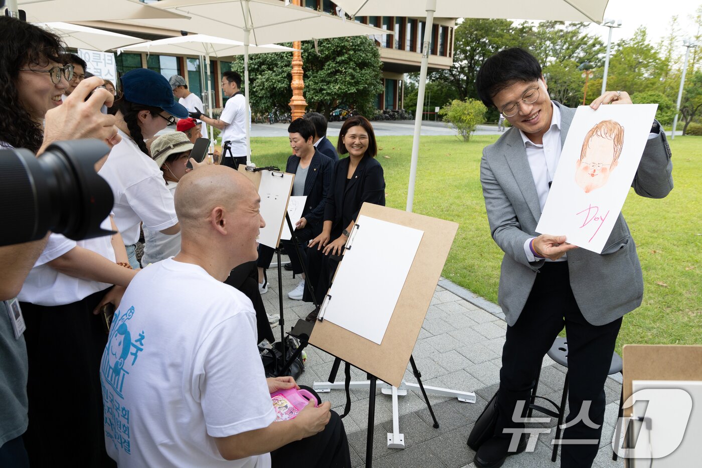 본문 이미지 - 박주민 국회 보건복지위원장이 27일 서울 여의도 국회 소통관 앞에서 열린 &#39;문신사법 의결 경축&#39; 타투이스트들의 캐리커쳐 행사에 참석해 캐리커쳐를 들고 있다. 2025.8.27/뉴스1 ⓒ News1 이승배 기자