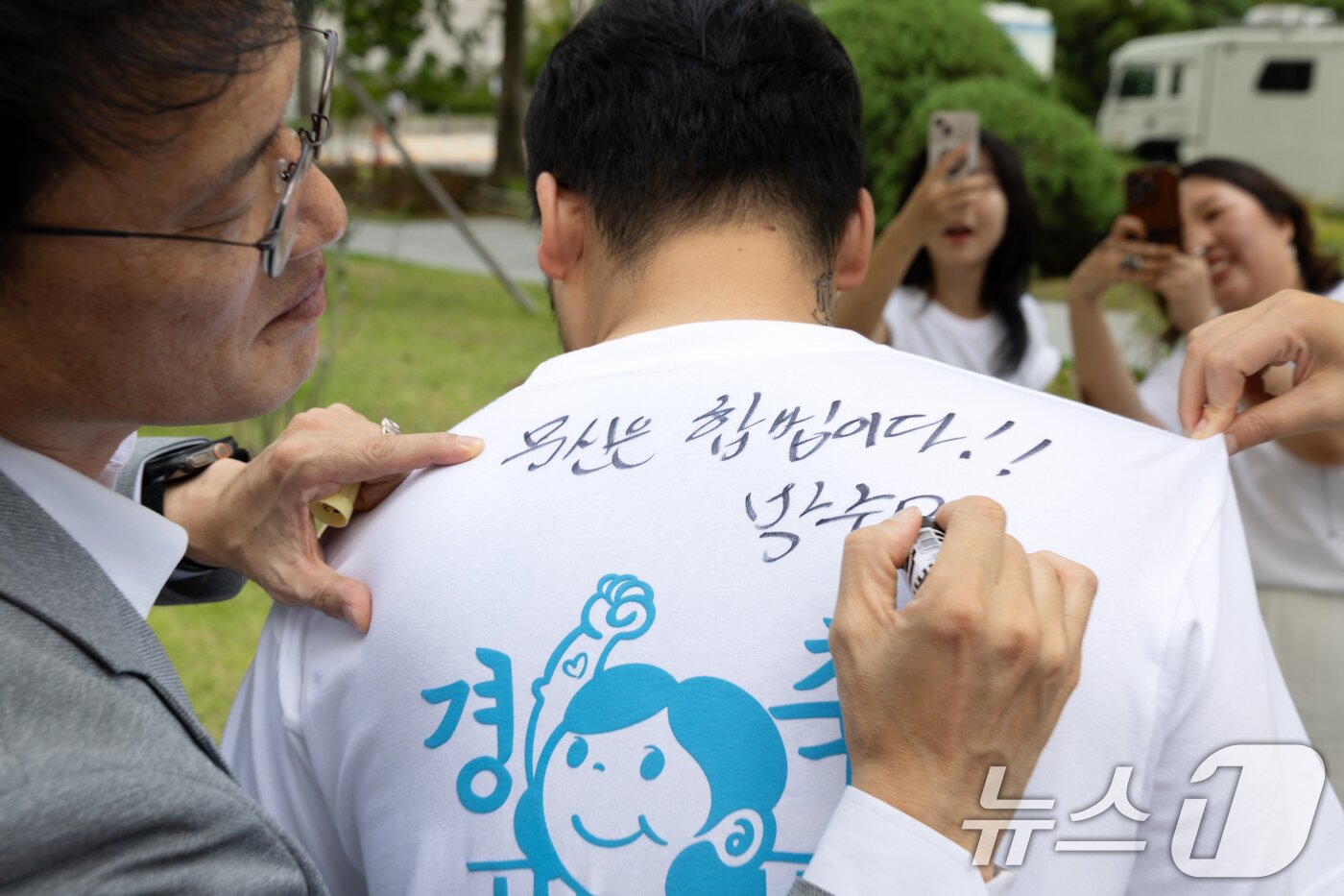 본문 이미지 - 박주민 국회 보건복지위원장이 27일 서울 여의도 국회 소통관 앞에서 열린 &#39;문신사법 의결 경축&#39; 타투이스트들의 캐리커쳐 행사에 참석한 뒤 타투이스트의 티셔츠에 사인을 해주고 있다. 2025.8.27/뉴스1 ⓒ News1 이승배 기자