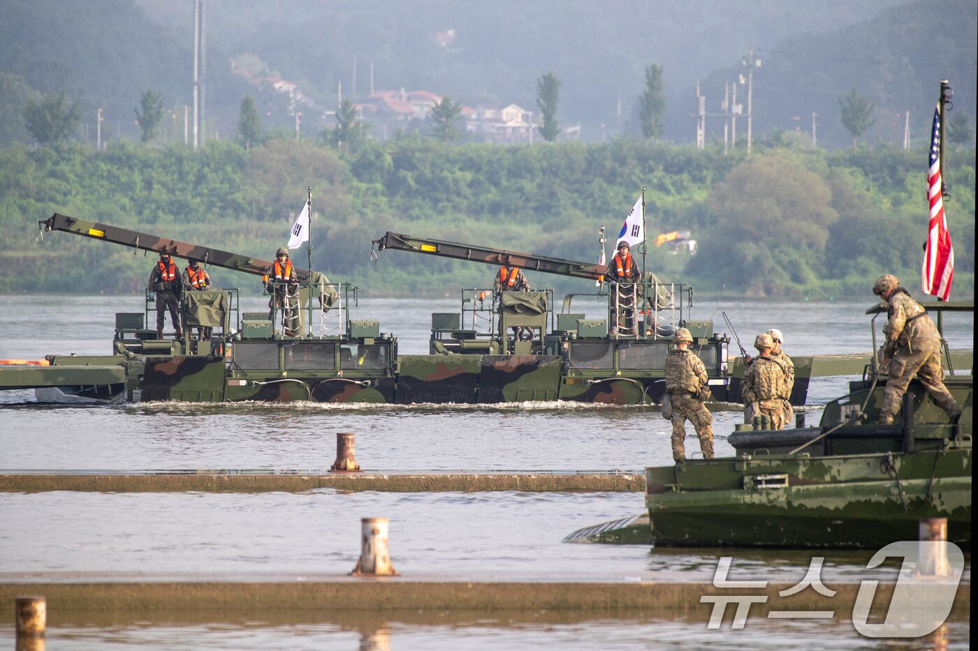 본문 이미지 - 육군 제7공병여단은 2025년 UFS/TIGER의 일환으로 지난 25일부터 27일까지 경기도 여주 남한강 일대에서 '한미연합 제병협동 도하훈련'을 실시했다. 한미연합 도하작전능력을 제고하기 위해 실시된 이번 훈련에는 한미 장병 300여 명과 한측 자주도하장비 수룡, 미측 스트라이커 장갑차 등 총 130여 대의 장비가 투입되었다. 사진은 자주도하장비 수룡과(왼쪽, 중앙) 미군의 교량가설단정이 도하작전을 실시하기 위해 물 위로 전개하고 있는 모습. (육군 제공. 재판매 및 DB 금지) 2025.8.27/뉴스1