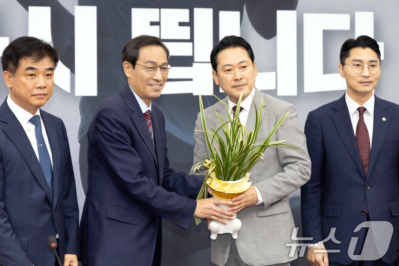 본문 이미지 - 장동혁 국민의힘 신임 당대표가 27일 오후 서울 여의도 국회에서 우상호 대통령실 정무수석으로부터 축하난을 받고 있다. 2025.8.27/뉴스1 ⓒ News1 이승배 기자