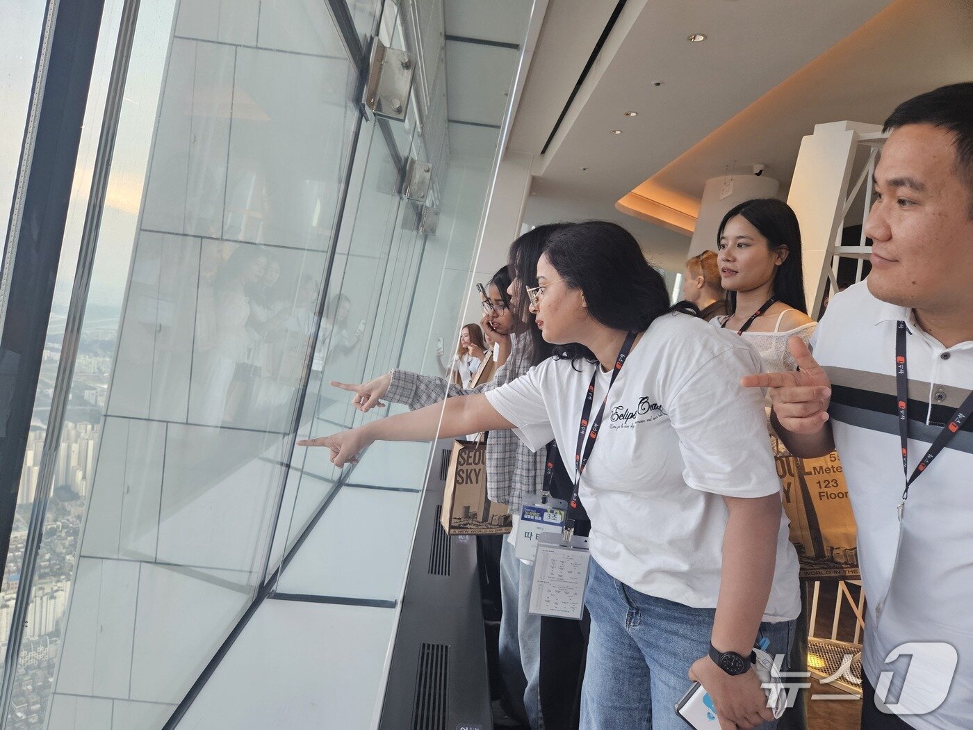 본문 이미지 - 27일 외국인을 대상으로 한 &#39;2025 K-브랜드 글로벌 캠프&#39;에서 서울 잠실 롯데월드타워 &#39;서울 스카이&#39;를 찾은 외국인 참가자들이 서울 전경을 구경하고 있다. /뉴스1 ⓒ News1 유채연 기자
