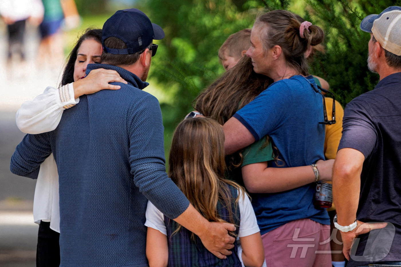 (로이터=뉴스1) = 27일(현지시간) 미국 미네소타주 미니애폴리스의 어넌시에이션 성당과 부속 학교 인근 총격 현장에서 시민들이 서로를 다독이며 위로하고 있다. 2025.8.28 …