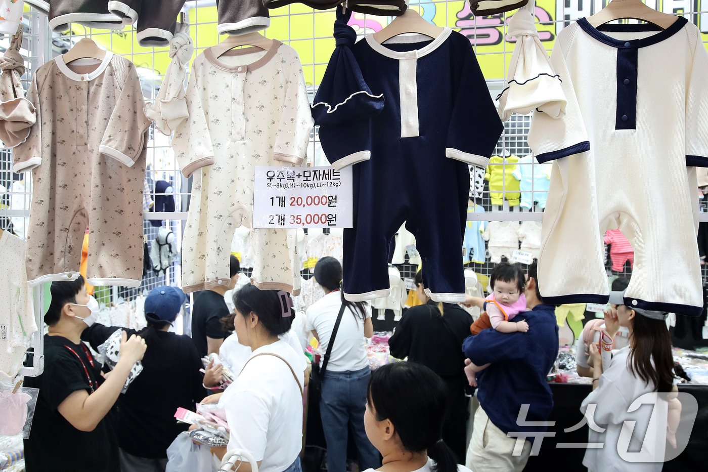 (대구=뉴스1) 공정식 기자 = 28일 대구 북구 엑스코(EXCO)에서 개막한 대구·경북 최대 규모의 육아박람회 '대구 베이비&키즈페어'를 찾은 부모들이 아기 옷을 꼼꼼히 살펴보고 …