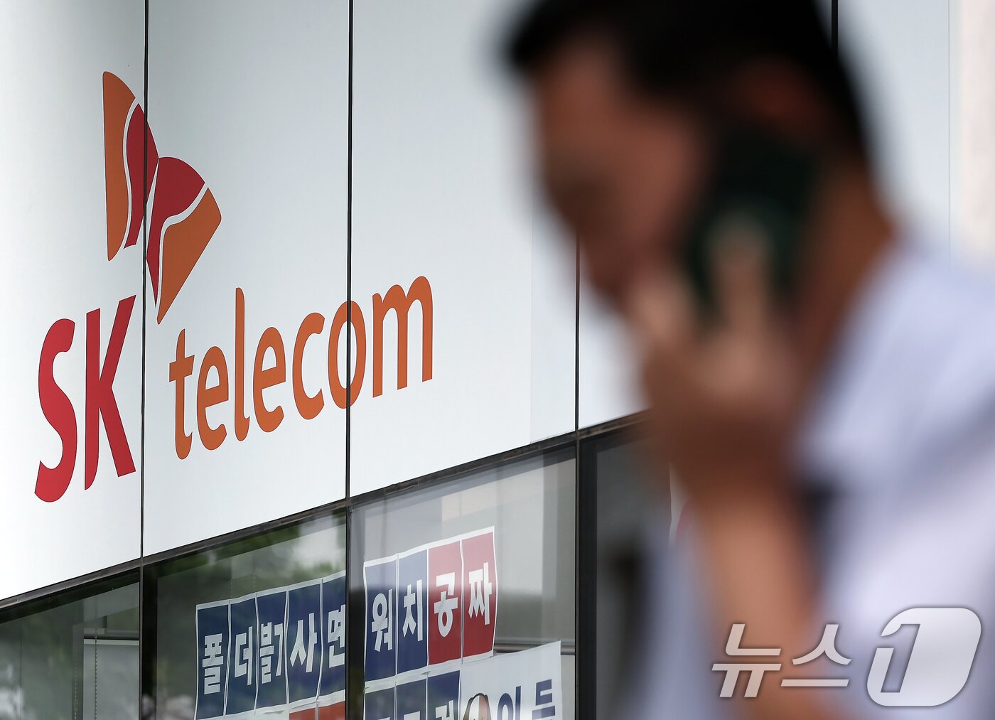 본문 이미지 - 서울 도심의 SK텔레콤 대리점 앞에서 한 시민이 전화 통화를 하고 있다. 2025.8.28/뉴스1 ⓒ News1 박정호 기자