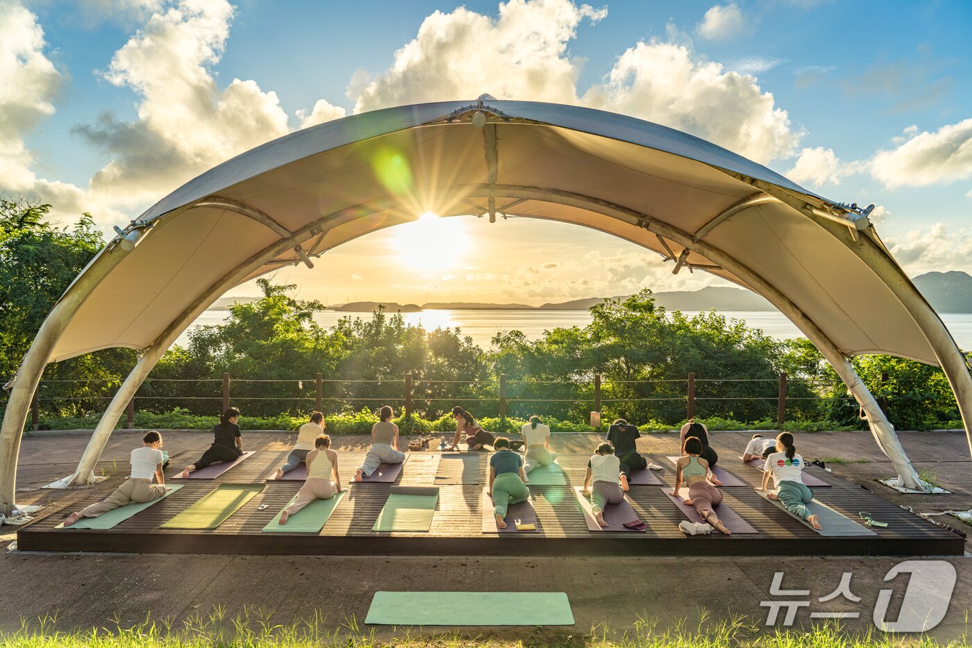 본문 이미지 - 강화유니버스 참가자들이 강화도의 노을을 배경으로 요가를 하고 있는 모습&#40;한국관광공사 제공&#41;