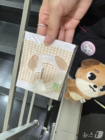 본문 이미지 - 25일 서울 서교동의 한 카페에서 보이밴드 데이식스 멤버 도운의 굿즈를 받은 팬의 모습. 2025.8.25/뉴스1 ⓒ News1 송송이 기자