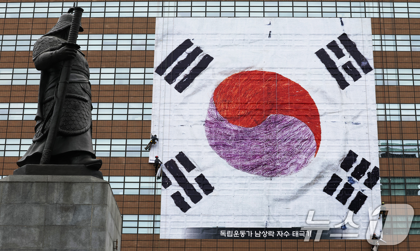 (서울=뉴스1) 장수영 기자 = 광복 80주년을 앞둔 3일 서울 종로구 광화문 교보생명 빌딩 외벽에 독립운동가 남상락 자수태극기가 래핑되고 있다. 2025.8.3/뉴스1