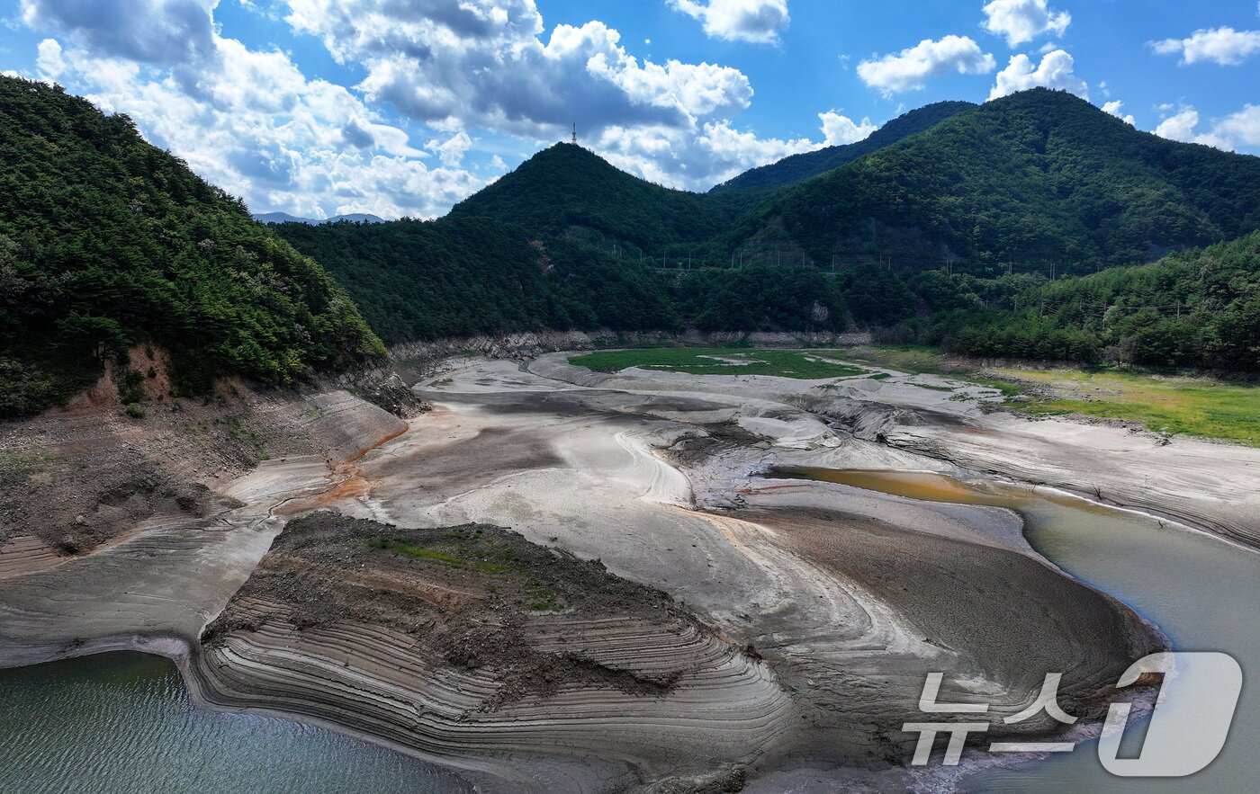 본문 이미지 - 강원 강릉지역이 사회재난이 아닌 자연재난으로는 사상 첫 재난 사태 지역으로 선포됐다. 행정안전부는 30일 오후 7시부로 극심한 가뭄을 겪고 있는 강원 강릉시 일원에 재난사태를 선포했다. 31일 한국농어촌공사 농촌용수종합정보시스템에 따르면 이날 오전 7시 40분께 오봉저수지 저수율은 14.9%로, 전날 15.3%에서 0.4%포인트 떨어졌다. 식수 공급의 마지노선으로 여겨진 저수율 15% 선이 무너지면서 강릉시는 수도 계량기 75%를 잠그는 제한 급수를 본격적으로 시행한다. 31일 강원 강릉시 주요 상수원인 오봉저수지 일대가 메말라 있다. 2025.8.31/뉴스1 ⓒ News1 김성진 기자
