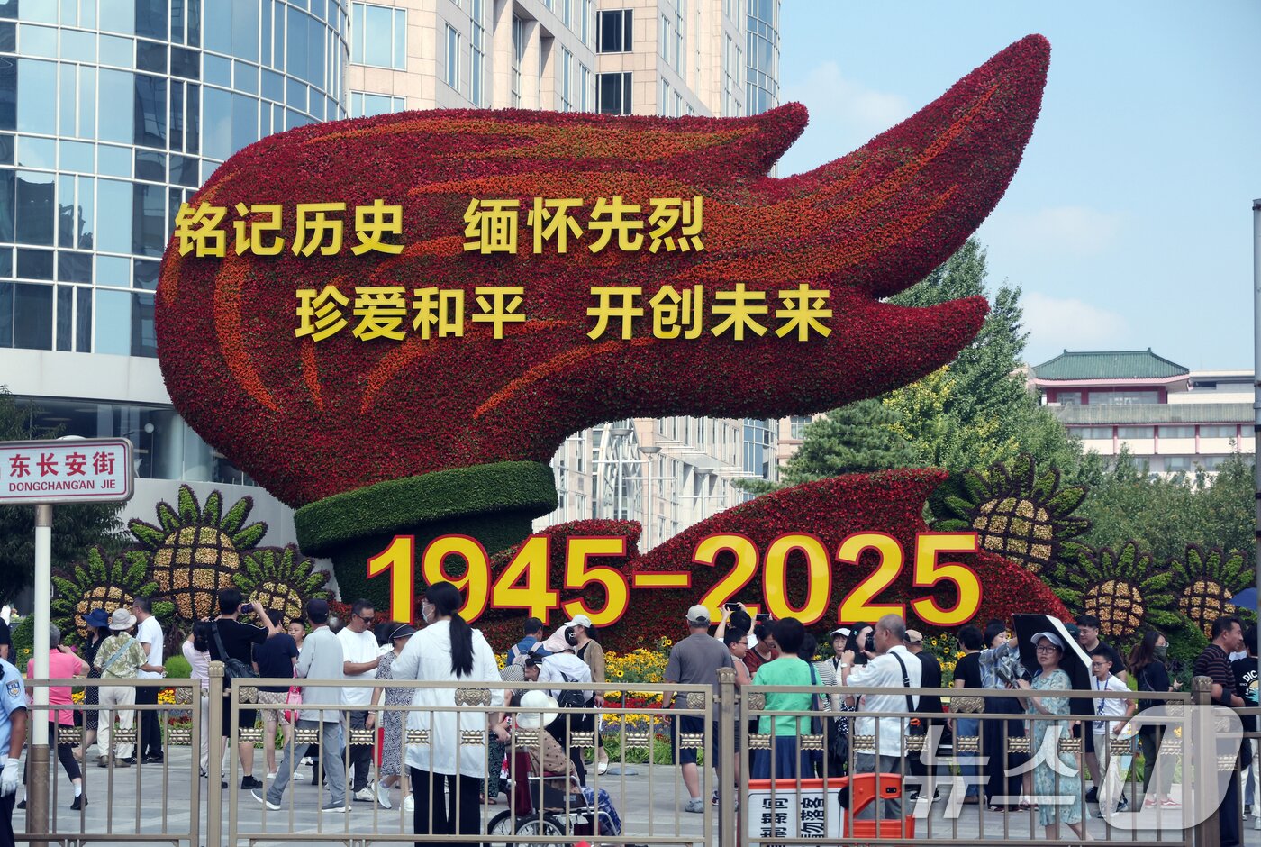 본문 이미지 - 중국의 항일전쟁 및 세계 반파시스트 전쟁&#40;제2차 세계대전&#41; 승리 80주년&#40;전승절&#41; 기념 열병식을 사흘 앞둔  지난달 31일 중국 베이징 천안문 인근 거리에 설치된 꽃 조형물 앞에서 행인들이 기념 사진을 찍고 있다. 2025.8.31/뉴스1 ⓒ News1 박정호 기자