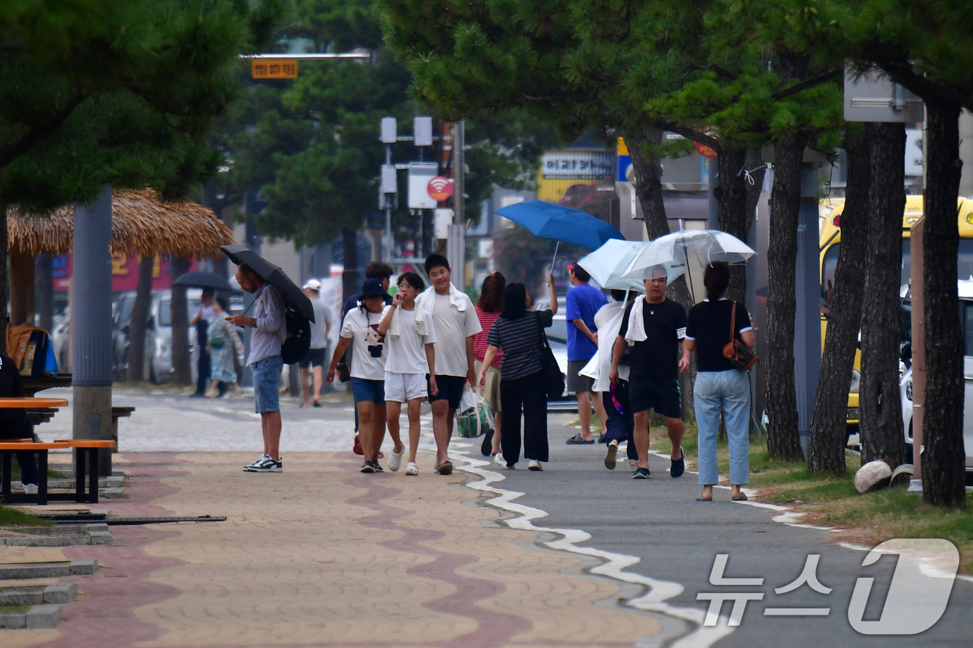 (포항=뉴스1) 최창호 기자 = 8월의 마지막 날인 31일 오후 경북 포항시 북구 영일대해수욕장을 찾은 관광객들이 이슬비를 피해 걸어가고 있다.  2025.8.31/뉴스1