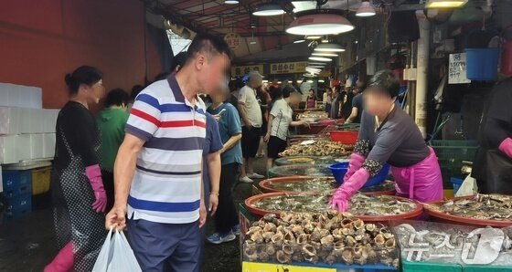 본문 이미지 - 31일 인천 남동구 소래포구 어시장을 찾은 방문객과 상인이 흥정하고 있다.